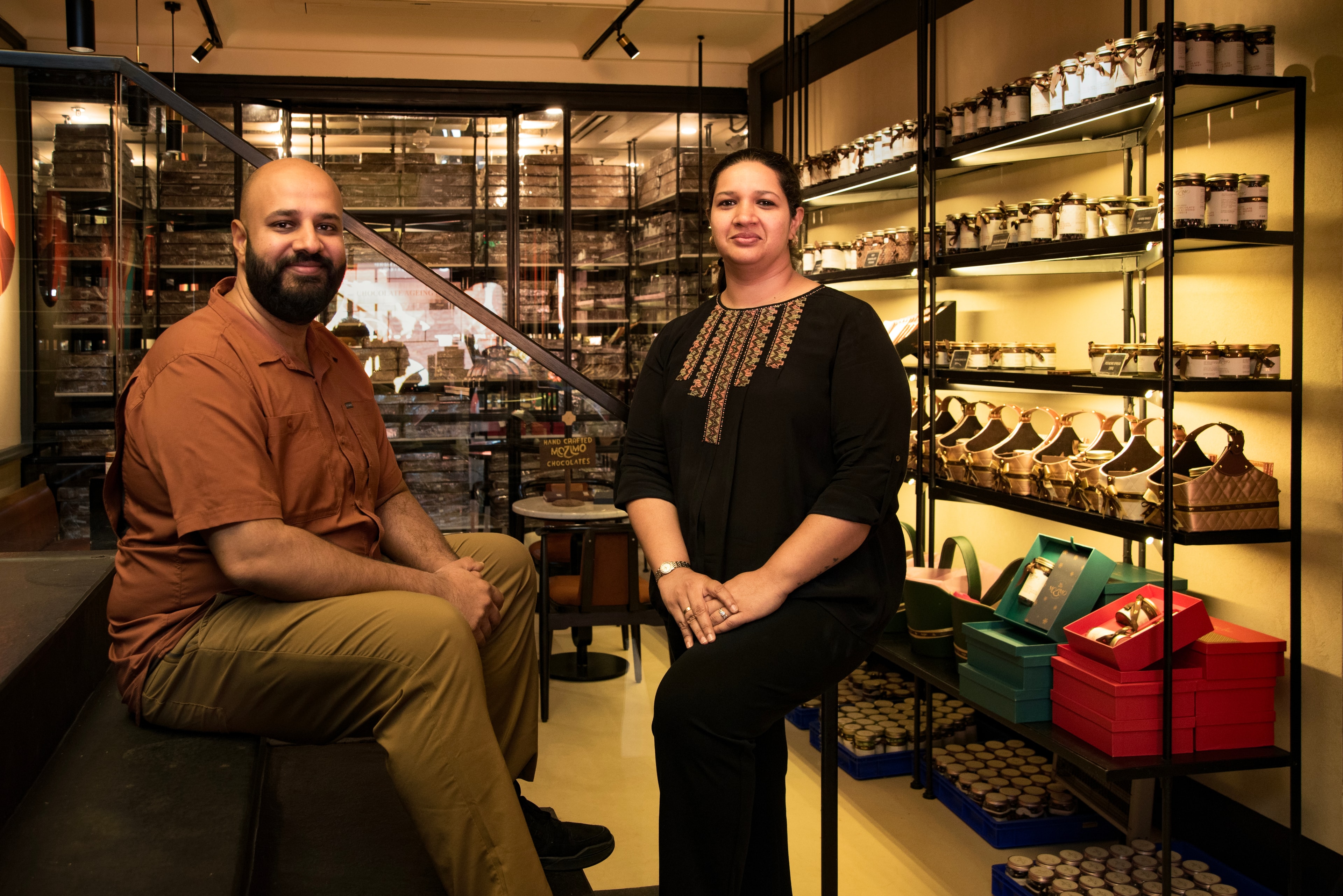Priyanka and Amritanshu, founders of Mozimo, sitting in their chocolate shop