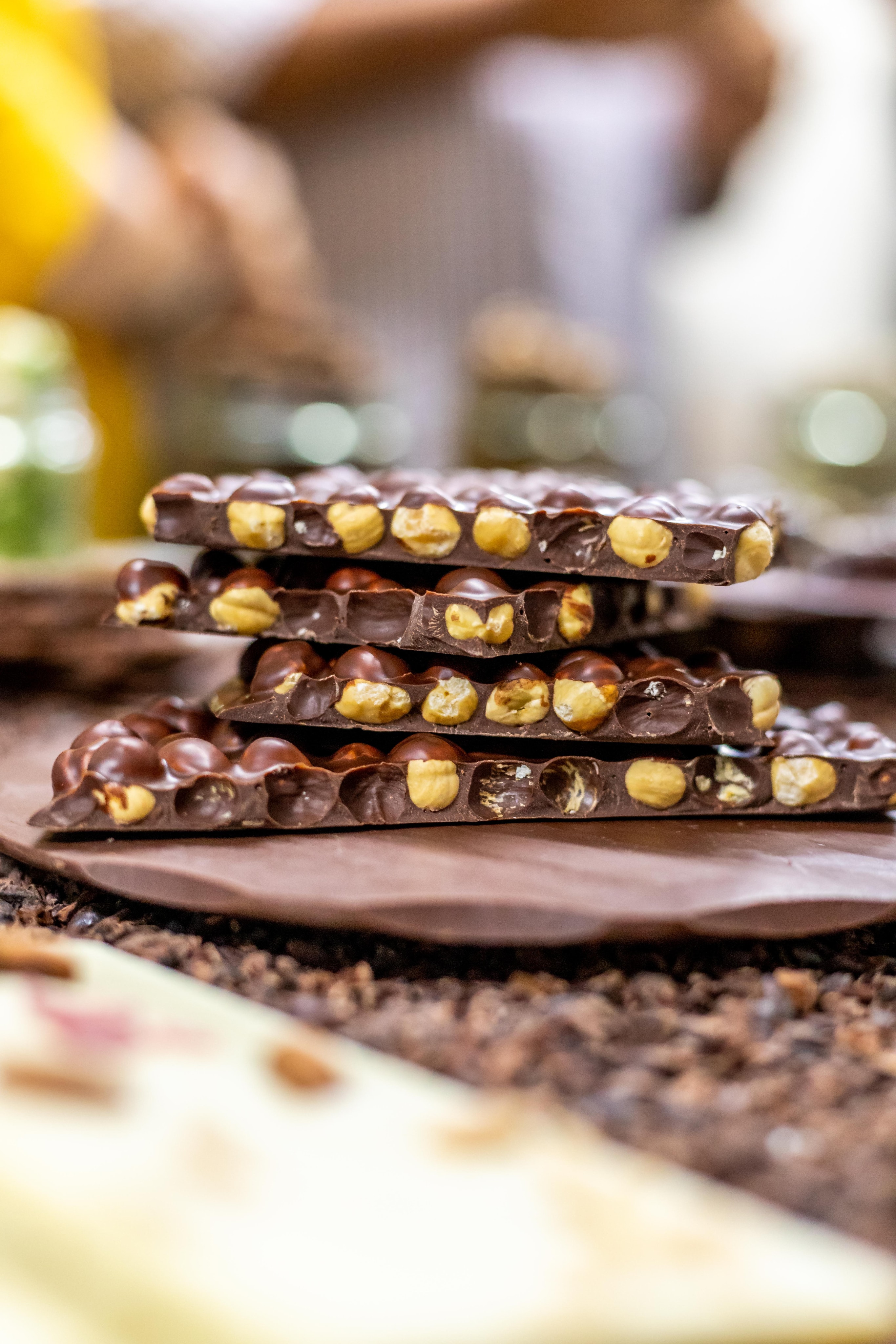 Thick chocolate bars with whole hazelnuts on chocolate shavings